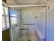 Shower with clear glass enclosure, grab bars, built-in seat, and decorative tile surround at 2037 Lakeshore Dr, Mount Dora, FL 32757
