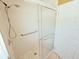 Clean shower with a glass door, white tile walls, and updated shower head at 2037 Lakeshore Dr, Mount Dora, FL 32757