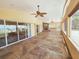 Enclosed sun room boasts a stone fireplace, ceiling fans and tiled floor with water views at 2037 Lakeshore Dr, Mount Dora, FL 32757