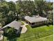 Aerial perspective of a house and separate outbuilding with verdant landscaping and a winding walkway at 2121 Suzanne Dr, Mount Dora, FL 32757