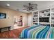 Comfortable bedroom featuring built-in shelving, a large bed, and wood flooring at 2121 Suzanne Dr, Mount Dora, FL 32757
