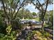 Charming home exterior with mature trees, a long driveway, and a glimpse of a well-maintained landscape at 2121 Suzanne Dr, Mount Dora, FL 32757