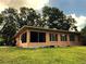 Spacious single-story home featuring a screened-in patio, well-maintained lawn, and mature shade trees at 2121 Suzanne Dr, Mount Dora, FL 32757