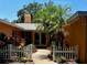 Inviting front entrance with a charming white picket fence and lush tropical landscaping at 2121 Suzanne Dr, Mount Dora, FL 32757