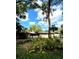 Charming single-story home featuring tropical landscaping, a white picket fence, and an attached two-car garage at 2121 Suzanne Dr, Mount Dora, FL 32757