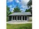Detached garage with three bays, each with large doors, set against a backdrop of mature trees at 2121 Suzanne Dr, Mount Dora, FL 32757