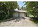 Exterior of a two car garage with a long concrete driveway and mature landscaping at 2121 Suzanne Dr, Mount Dora, FL 32757
