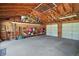 Garage interior with exposed ceiling, pegboard wall, work bench and two overhead doors at 2121 Suzanne Dr, Mount Dora, FL 32757