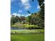 Scenic lake view with lush greenery and a glimpse of the charming home nestled among the trees on a sunny day at 2121 Suzanne Dr, Mount Dora, FL 32757