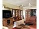 Bright living room showcasing paneled glass doors, ceiling fan, and comfortable seating with a decorative rug at 2121 Suzanne Dr, Mount Dora, FL 32757