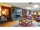 Cozy living room with a stone fireplace, hardwood floors, and comfortable seating at 2121 Suzanne Dr, Mount Dora, FL 32757