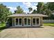 Exterior of an outbuilding featuring multiple sets of glass french doors and a concrete drive at 2121 Suzanne Dr, Mount Dora, FL 32757