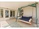 Comfortable back porch swing with blue cushions and a nice floor covering at 2204 Margarita Dr, The Villages, FL 32159