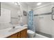 Bright bathroom with a white marble sink, matching toilet, and a shower enclosed with a blue patterned curtain at 2204 Margarita Dr, The Villages, FL 32159