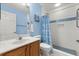 The bathroom features a shower with white tile and a blue accent stripe at 2204 Margarita Dr, The Villages, FL 32159
