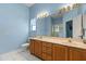 Bright bathroom featuring a double vanity and large mirror at 2204 Margarita Dr, The Villages, FL 32159
