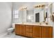 Bright bathroom features double sinks, a large mirror, and ample lighting fixtures at 2204 Margarita Dr, The Villages, FL 32159