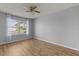 This bedroom features wood-look flooring, a ceiling fan, and a sunny window at 2204 Margarita Dr, The Villages, FL 32159