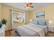 Comfortable bedroom featuring a large window, a tufted headboard, and an area rug at 2204 Margarita Dr, The Villages, FL 32159