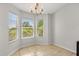 Sunny breakfast nook featuring large windows, tile flooring, and chandelier lighting at 2204 Margarita Dr, The Villages, FL 32159