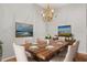 Formal dining room with a wood table, white chairs, and a chandelier at 2204 Margarita Dr, The Villages, FL 32159