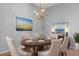 Formal dining room with elegant wood table set for six, a chandelier, and artwork at 2204 Margarita Dr, The Villages, FL 32159