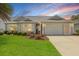 Charming single-story home with a well-manicured lawn, beautiful landscaping, and a two-car garage at 2204 Margarita Dr, The Villages, FL 32159