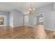 Open-concept living space with wood floors and chandelier, connecting to kitchen and outdoor views at 2204 Margarita Dr, The Villages, FL 32159