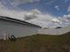 View of home's backyard with solar panels, showcasing a pristine white fence and well-kept lawn at 2256 Gladiolus Ln, Mascotte, FL 34753