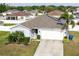 Inviting one-story home with a two-car garage, landscaped front yard, and solar panels on the roof at 2256 Gladiolus Ln, Mascotte, FL 34753