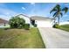 Single-story home featuring a two-car garage, green lawn, and a well-maintained front yard at 2256 Gladiolus Ln, Mascotte, FL 34753