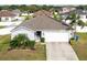 Charming single-story home featuring a two-car garage, well-manicured landscaping, and solar panels at 2256 Gladiolus Ln, Mascotte, FL 34753
