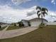 Charming single-story home featuring a two-car garage, palm trees, and a well-maintained front yard at 2256 Gladiolus Ln, Mascotte, FL 34753