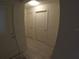 Hallway featuring multiple doors, white trim and light wood-look flooring at 2256 Gladiolus Ln, Mascotte, FL 34753