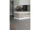 Updated kitchen boasts stone accent wall, modern sink, white cabinets, and stainless steel refrigerator at 234 Afton Sq # 205, Altamonte Springs, FL 32714