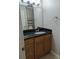 Bathroom vanity with black granite countertops, wood cabinets, large mirror, and modern faucet at 236 Afton Sq # 309, Altamonte Springs, FL 32714
