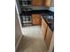 Functional kitchen area featuring stainless steel appliances, wood cabinets, granite countertops, and easy-to-clean tile floor at 236 Afton Sq # 309, Altamonte Springs, FL 32714