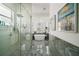 Bright bathroom featuring a soaking tub, a glass-enclosed shower, and gray marble floors at 2497 Heritage Green Ave, Davenport, FL 33837
