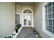 Inviting entryway with double doors, tile flooring, and decorative plants. 