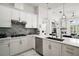Modern kitchen boasts white cabinets, stainless steel appliances, and a stylish backsplash at 2497 Heritage Green Ave, Davenport, FL 33837