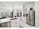 Open-concept kitchen with stainless steel appliances, island and bar seating and white cabinets at 2497 Heritage Green Ave, Davenport, FL 33837