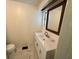 Bright bathroom with a stylish vanity, framed mirror, and marble-look tile flooring at 25 Captains Pt, Fruitland Park, FL 34731