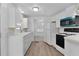 Updated kitchen featuring white cabinetry, appliances, and luxury vinyl plank flooring at 25 Captains Pt, Fruitland Park, FL 34731