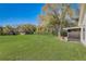 Large, grassy backyard with mature trees and a patio area, perfect for outdoor activities at 25273 Lost Oak Cir, Leesburg, FL 34748