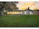 View of the home's backyard featuring a large glass enclosed sunroom with solar panels at 25273 Lost Oak Cir, Leesburg, FL 34748