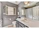 Bathroom featuring a white vanity, large mirror and a window with white shutters at 25273 Lost Oak Cir, Leesburg, FL 34748