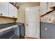 Practical laundry room with modern washer and dryer and ample cabinet storage at 25273 Lost Oak Cir, Leesburg, FL 34748