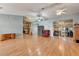 Open-concept living area with hardwood floors, ceiling fans, and an adjacent kitchen area at 25273 Lost Oak Cir, Leesburg, FL 34748