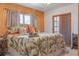 A cozy bedroom with wood-paneled walls, soft lighting, a printed bed spread and a resting cat at 2529 Cr 448, Lake Panasoffkee, FL 33538