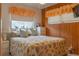 This charming bedroom features wood-paneled walls, soft lighting, and a cozy bed, creating a relaxing retreat at 2529 Cr 448, Lake Panasoffkee, FL 33538